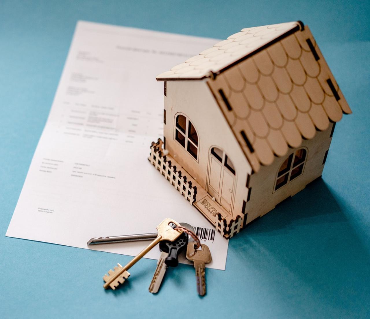 House miniature next to real estate contract