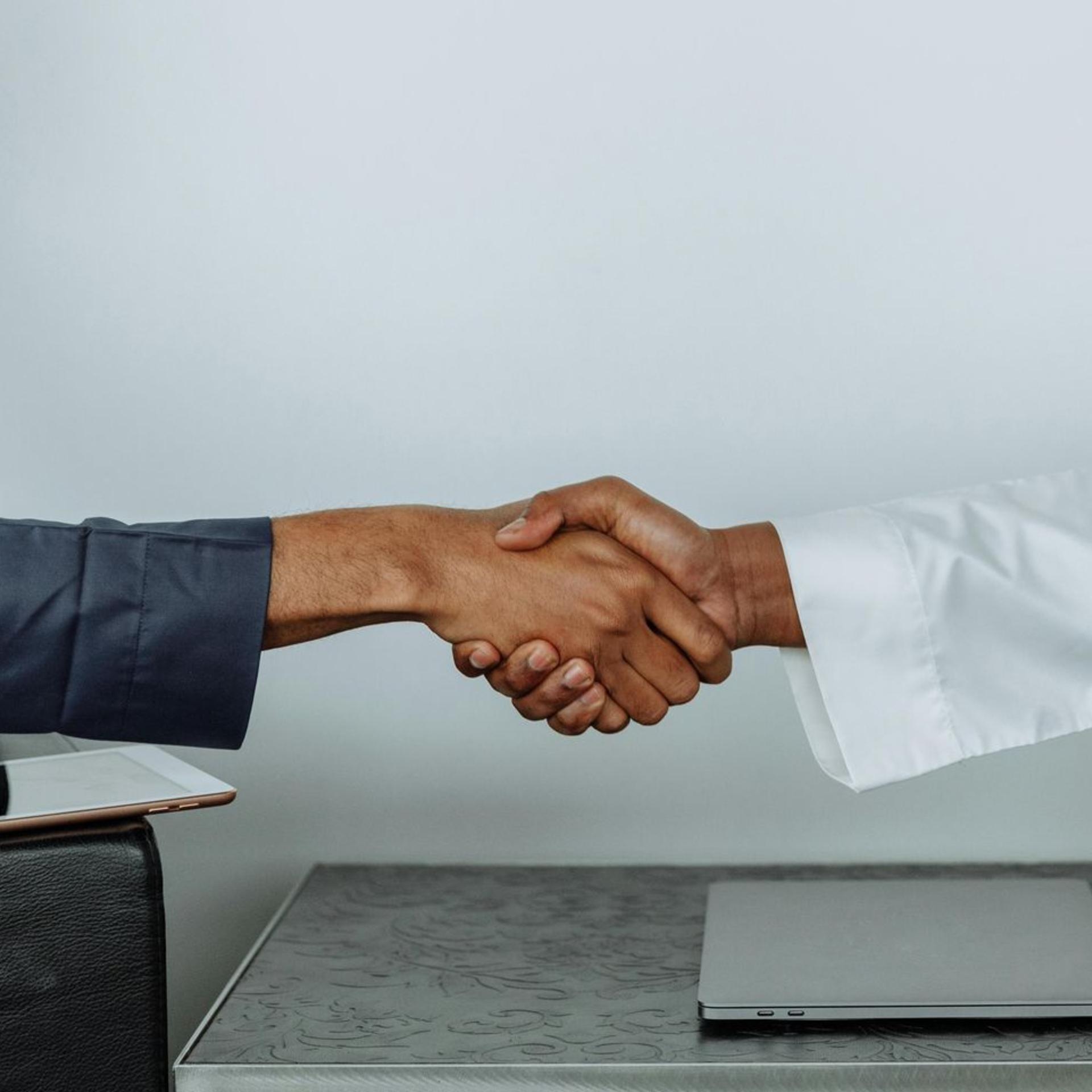 Shows hands shaking to seal a deal